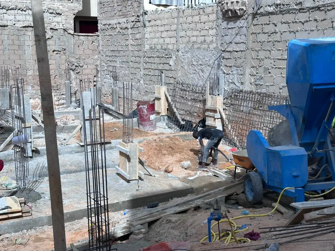 Poteaux coffrés et bétonnière sur le chantier